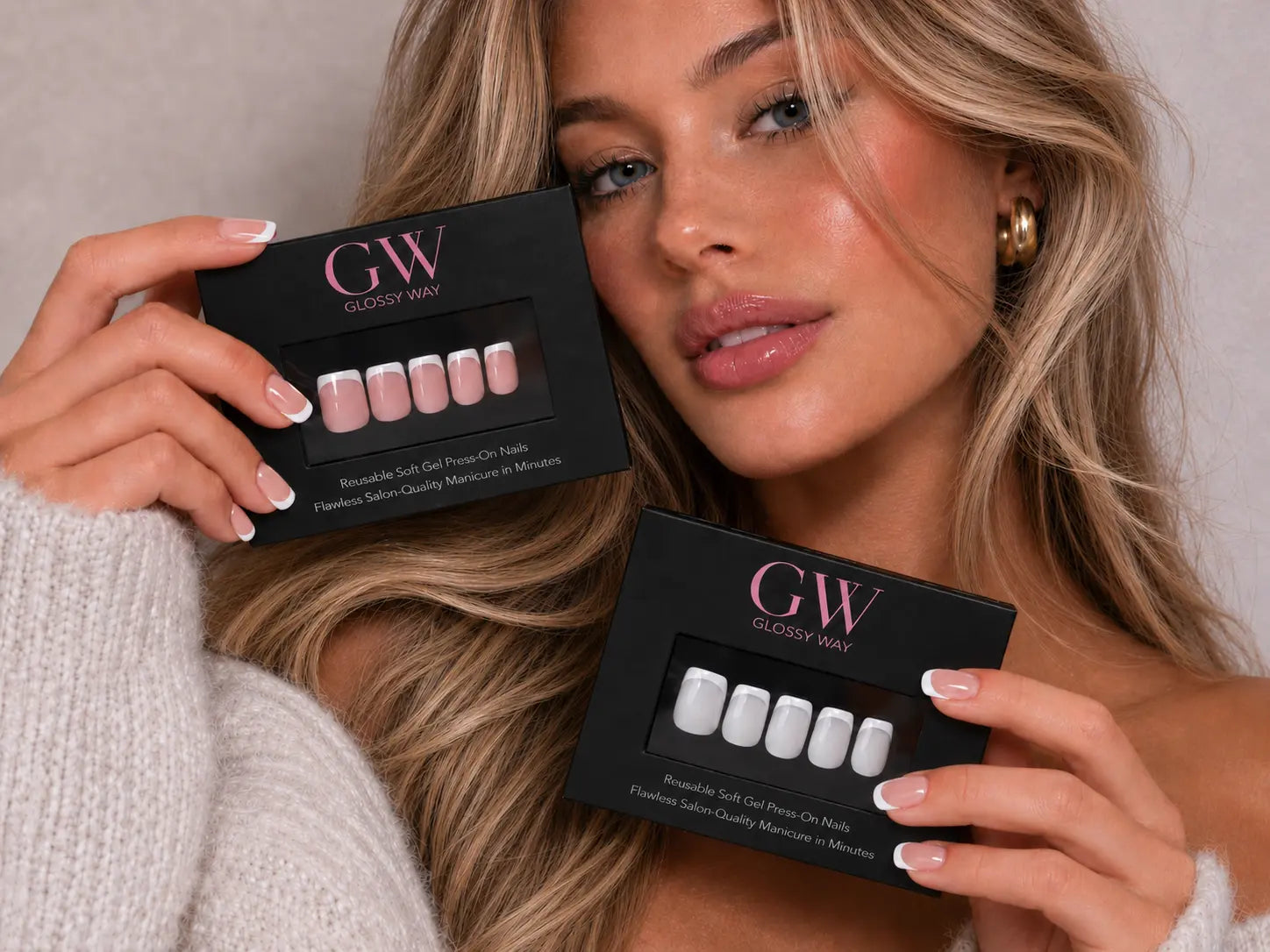 A woman holds two black GW Glossy Way artificial nail press-on boxes, one showing pink nails and the other showing white nails, in a close-up lifestyle shot.