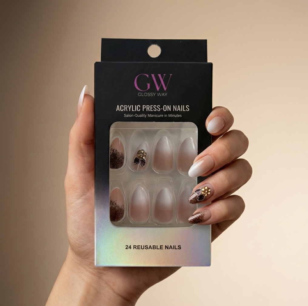 A hand holding a black glossy way press-on nails box, showing 24 reusable acrylic press-on nails in a sheer nude shade with some glitter accents visible through the clear window.
