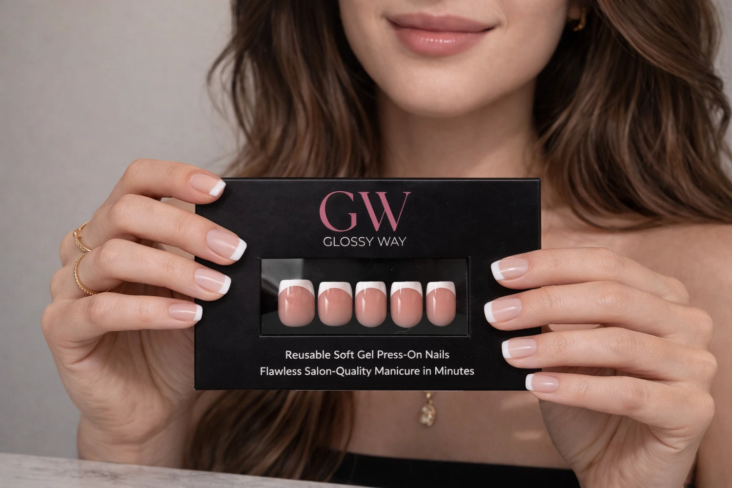 Model holding a Glossy Way press-on nail product packaging with nails displayed.