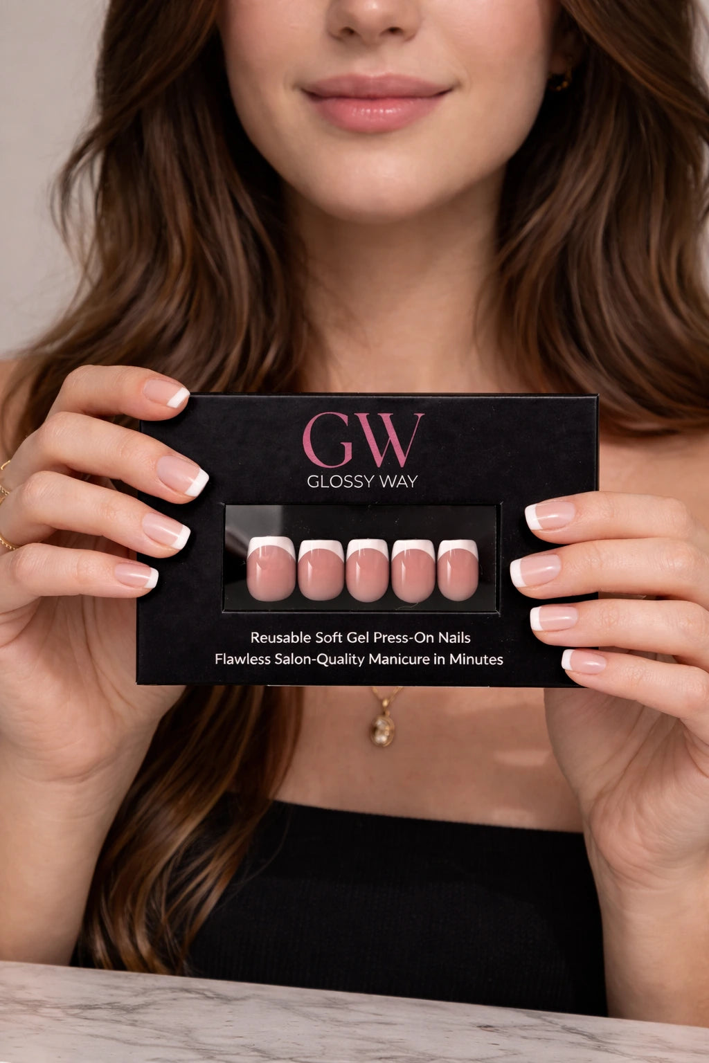 Model holding a Glossy Way product packaging with nails displayed.