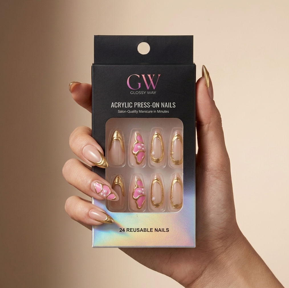 A hand holds a black box of GW Closely Wav Acrylic Press-On Nails against a warm beige background. The nails visible through the clear window are almond-shaped with gold glitter borders, two with pink glitter swirls, and two with a pink glitter swirl and a small gold heart.
